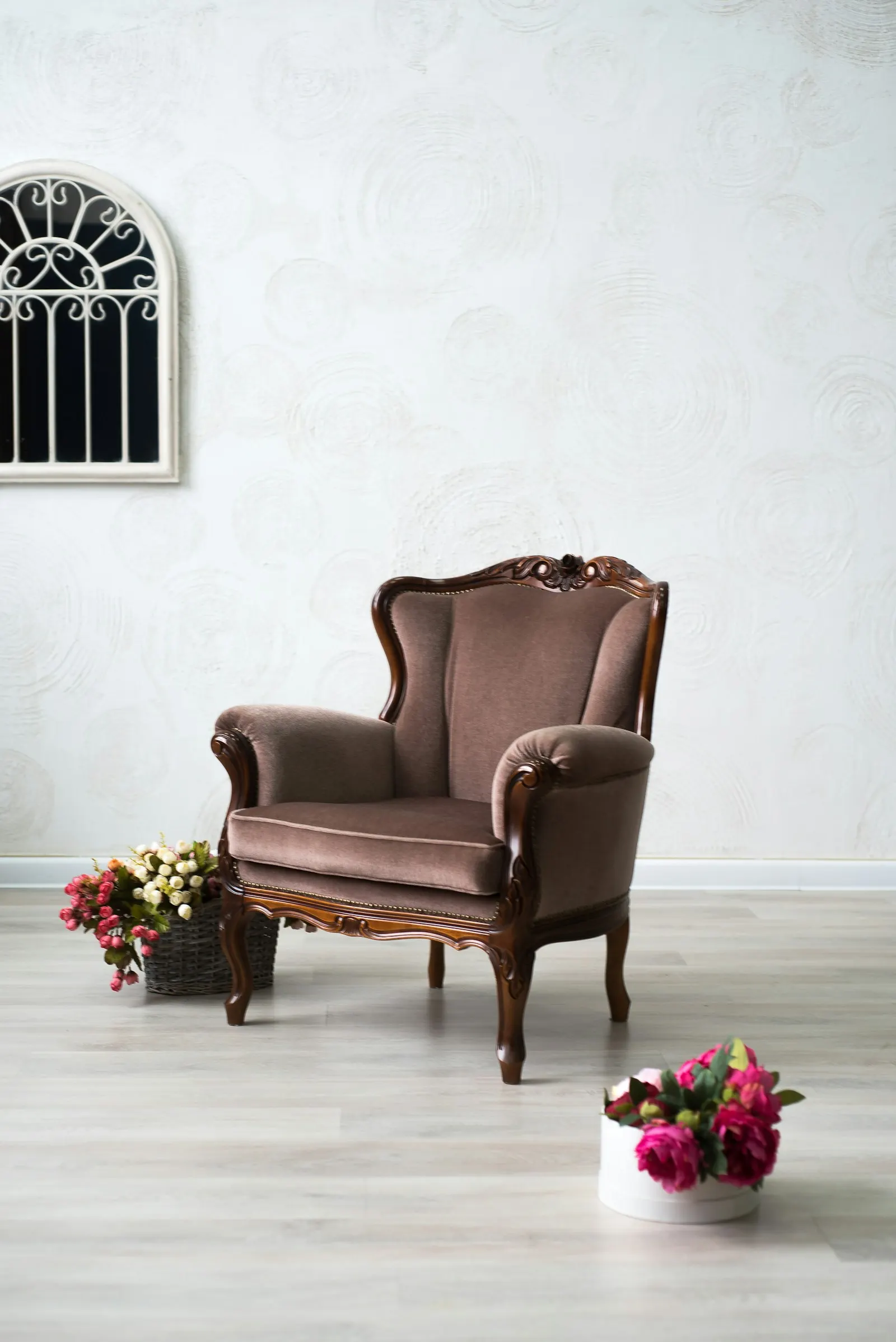 A carved antique armchair with brown upholstery
