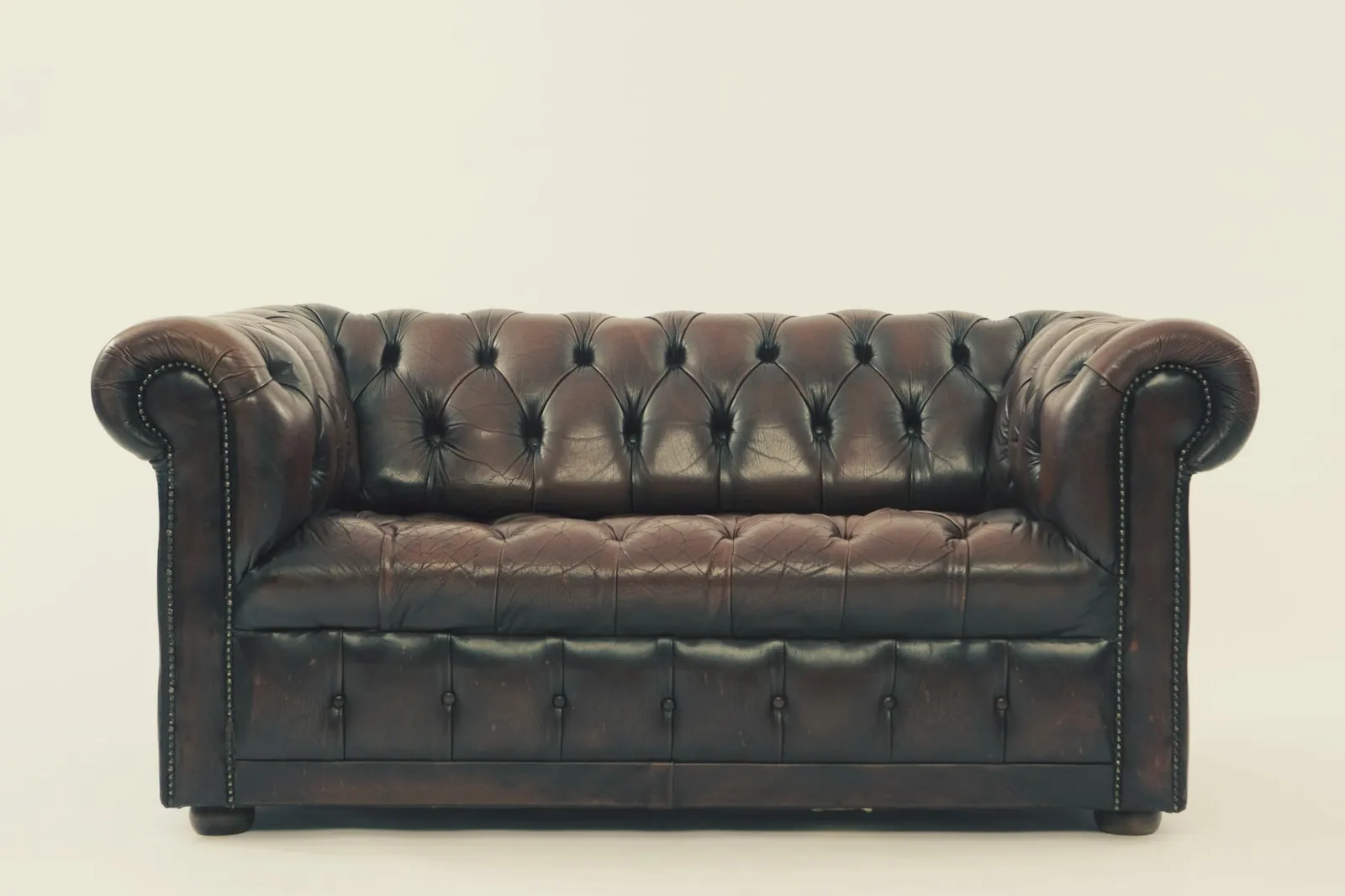 A dark brown leather chesterfield sofa