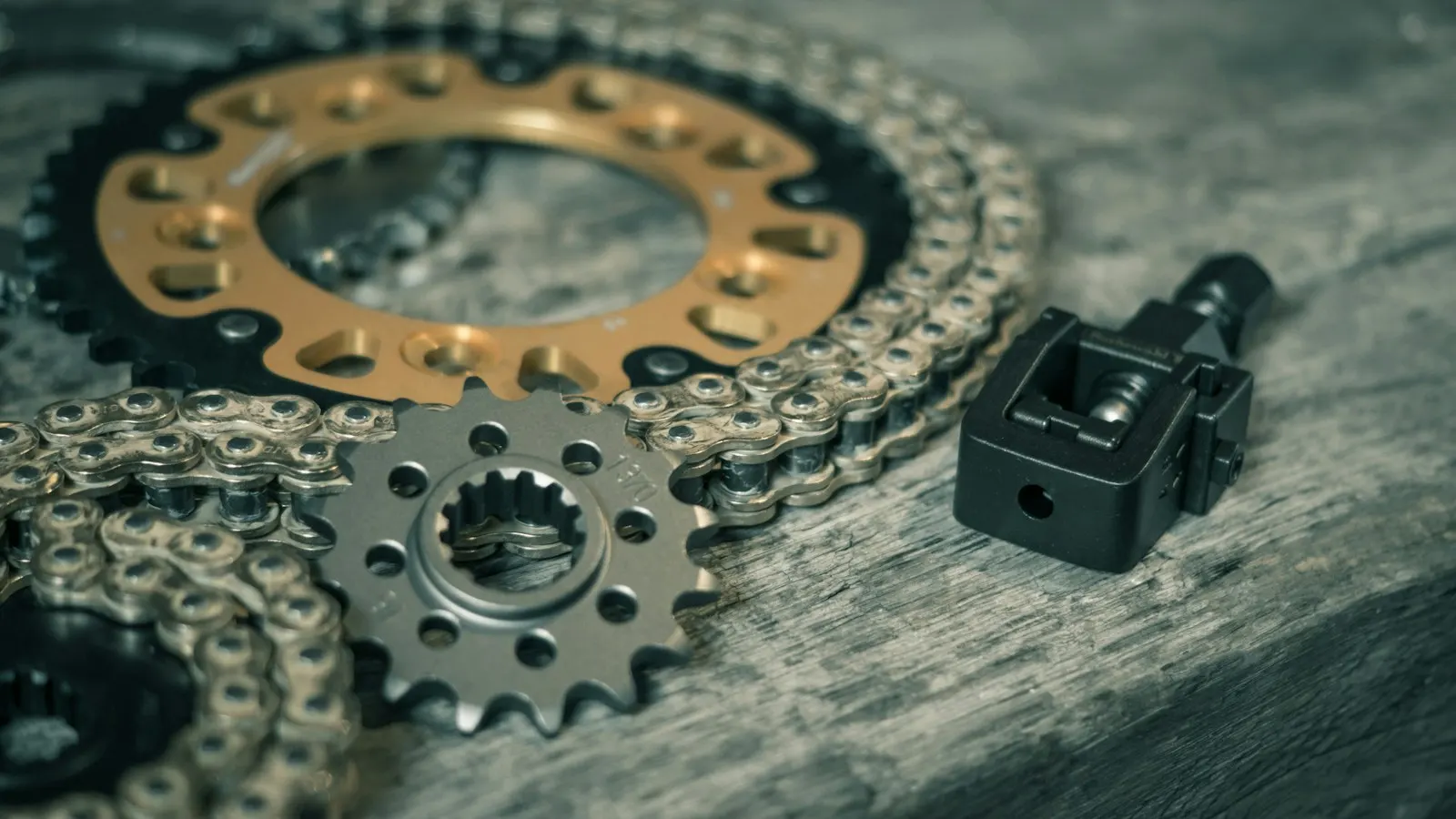 Motorcycle sprockets and a chain on a workbench