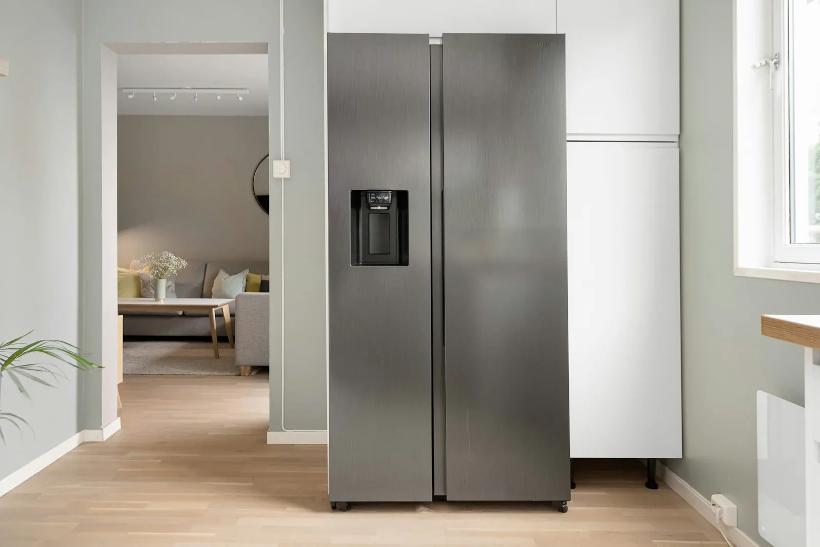 A stainless side-by-side refrigerator in a bright kitchen